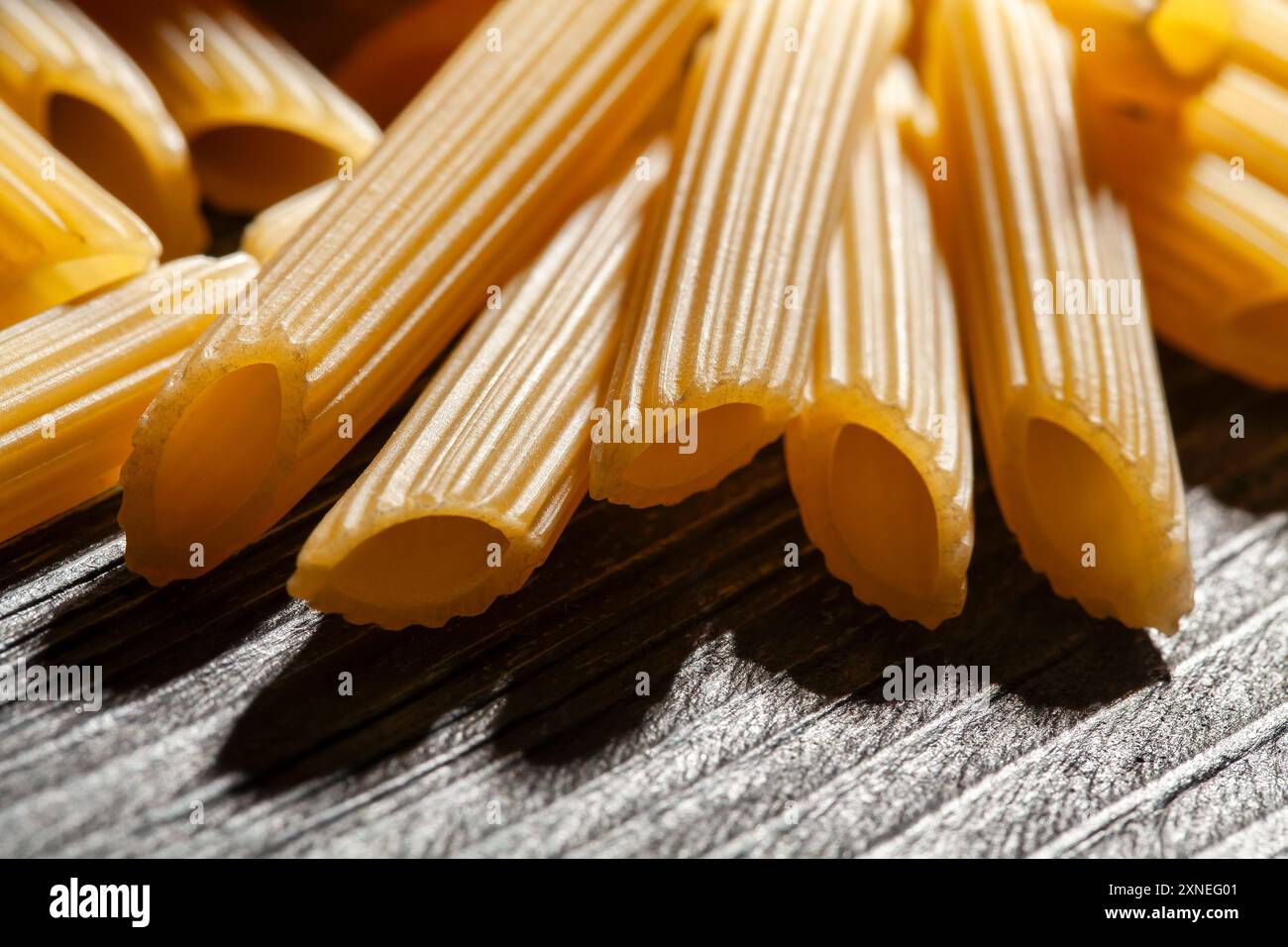 Pasta Penne Rigate auf Holz Hintergrund Makro Stockfoto