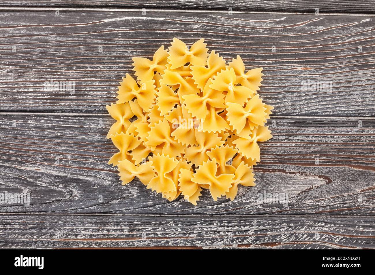 Pasta Farfalle auf Holzhintergrund von oben Stockfoto