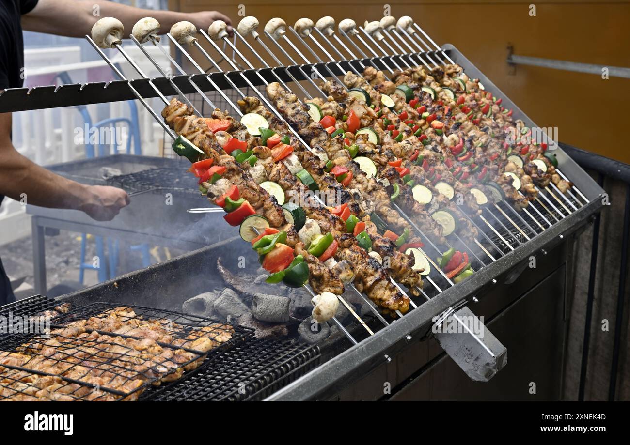 Fleisch- und Gemüsekebabs grillen auf rotierenden Spießen über Holzkohlegrill Stockfoto
