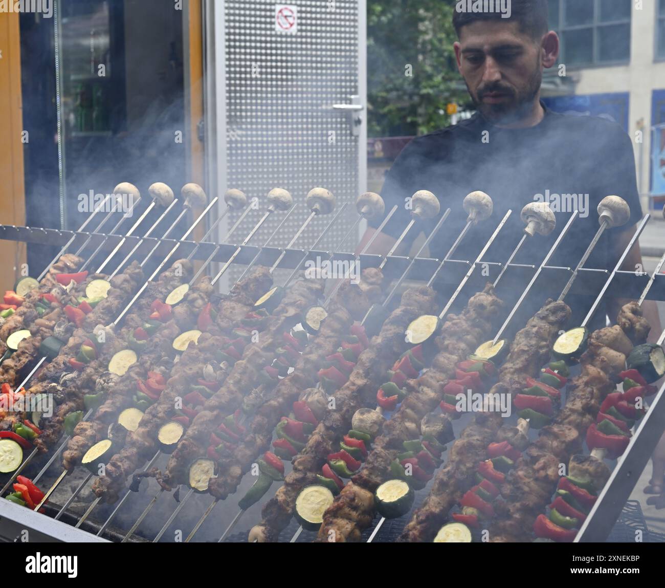 Fleisch- und Gemüsekebabs grillen auf rotierenden Spießen über Holzkohlegrill Stockfoto
