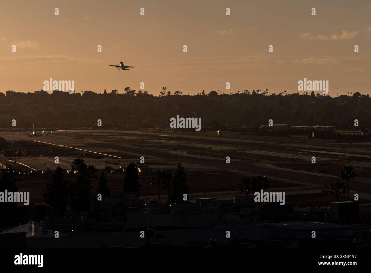 Ein Flugzeug startet bei Sonnenuntergang vom Flughafen San Diego. Stockfoto