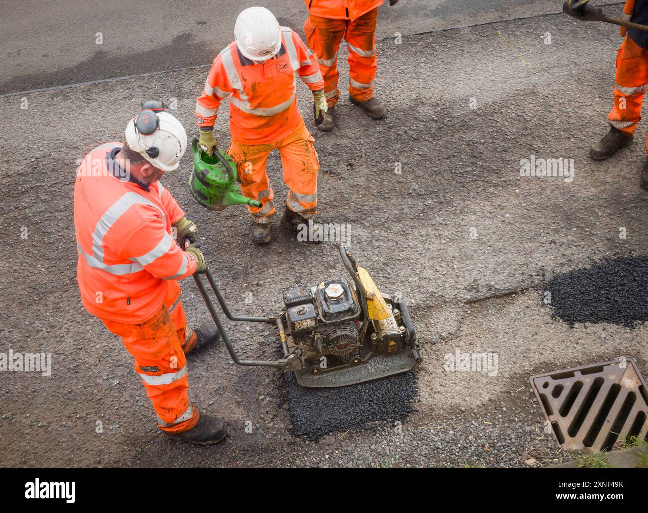 BUCKINGHAMSHIRE, Großbritannien - 19. März 2024. Straßenarbeiter reparieren Schlaglöcher. Provisorische Schlagloch-Patch-Reparaturen auf einer Landstraße im Verfall. Stockfoto
