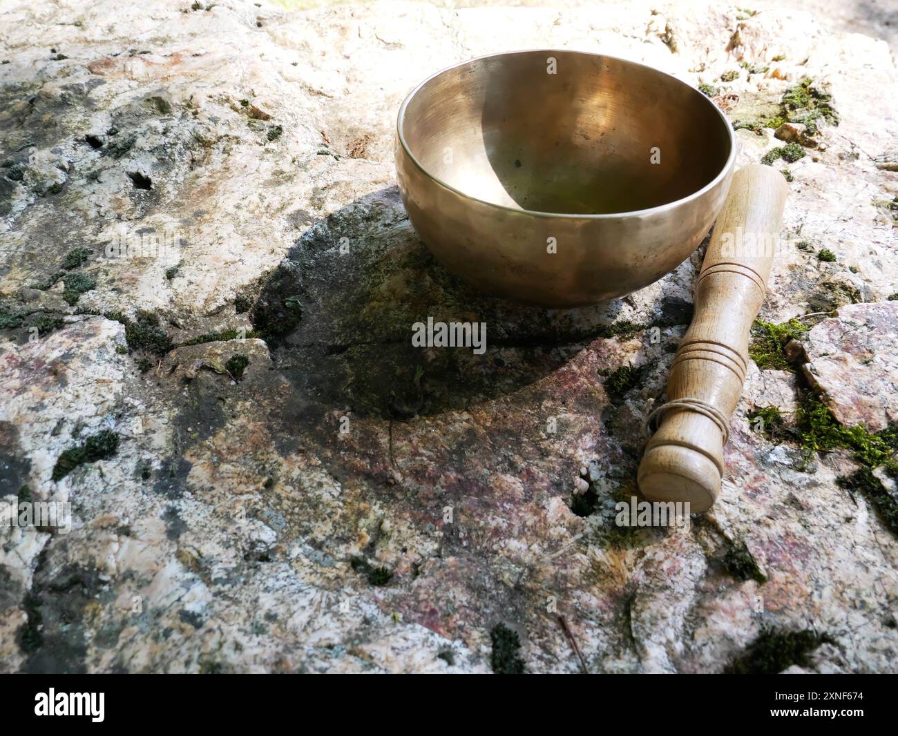 Ein Foto von einer Klangschale auf einem Felsen Stockfoto