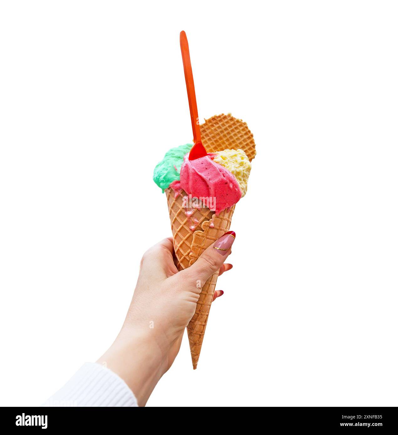 Frauenhand mit Waffelkegel mit Erdbeere, Pistazien und Vanilleeis auf weißem Hintergrund. Eisbecher auf weißem Hintergrund. Stockfoto
