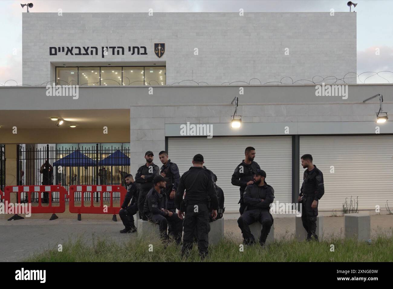 KFAR YONA, ISRAEL - JULI 30: Mitglieder der israelischen Sicherheitskräfte stehen Wache, während sich rechte Israelis zu einem Protest vor einem Militärgericht in der Armeebasis Beit Lid versammeln und die Freilassung von neun Reservisten fordern, die wegen Folter eines Gefangenen aus Gaza inhaftiert worden waren. nach dem Angriff der Hamas am 7. Oktober 30 2024 in Kfar Yona, Israel. Am 29. Juli drangen rechtsextreme Demonstranten in das Gelände von Sde Teiman ein, um Unterstützung für israelische Reservisten zu zeigen, die wegen des Missbrauchs eines palästinensischen Gefangenen inhaftiert wurden. Stockfoto