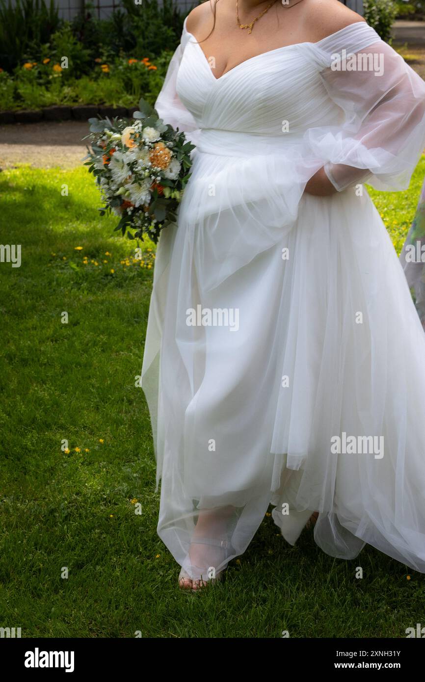 Hochzeitskleid und Blumenstab Stockfoto