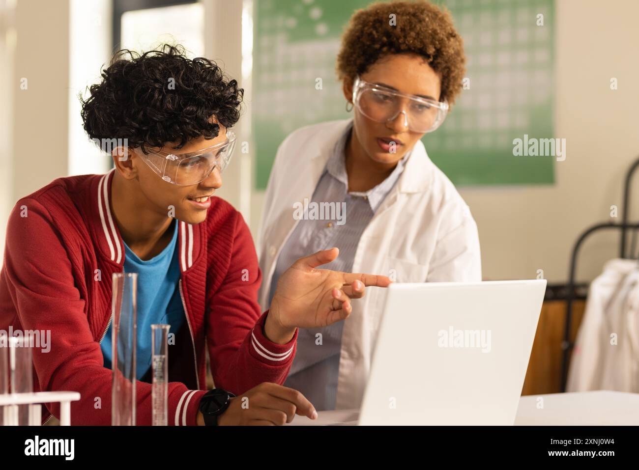 In der Highschool, Teenager, die Laptop benutzen und im Labor über Wissenschaftsprojekte diskutieren Stockfoto