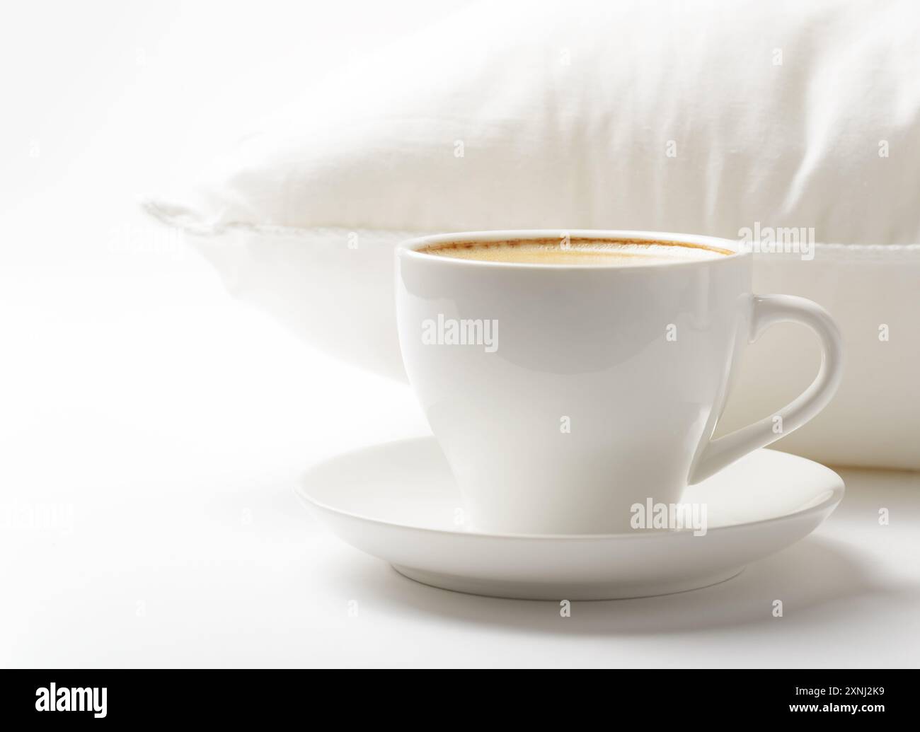 Tasse Kaffee und weißes Kissen Stockfoto