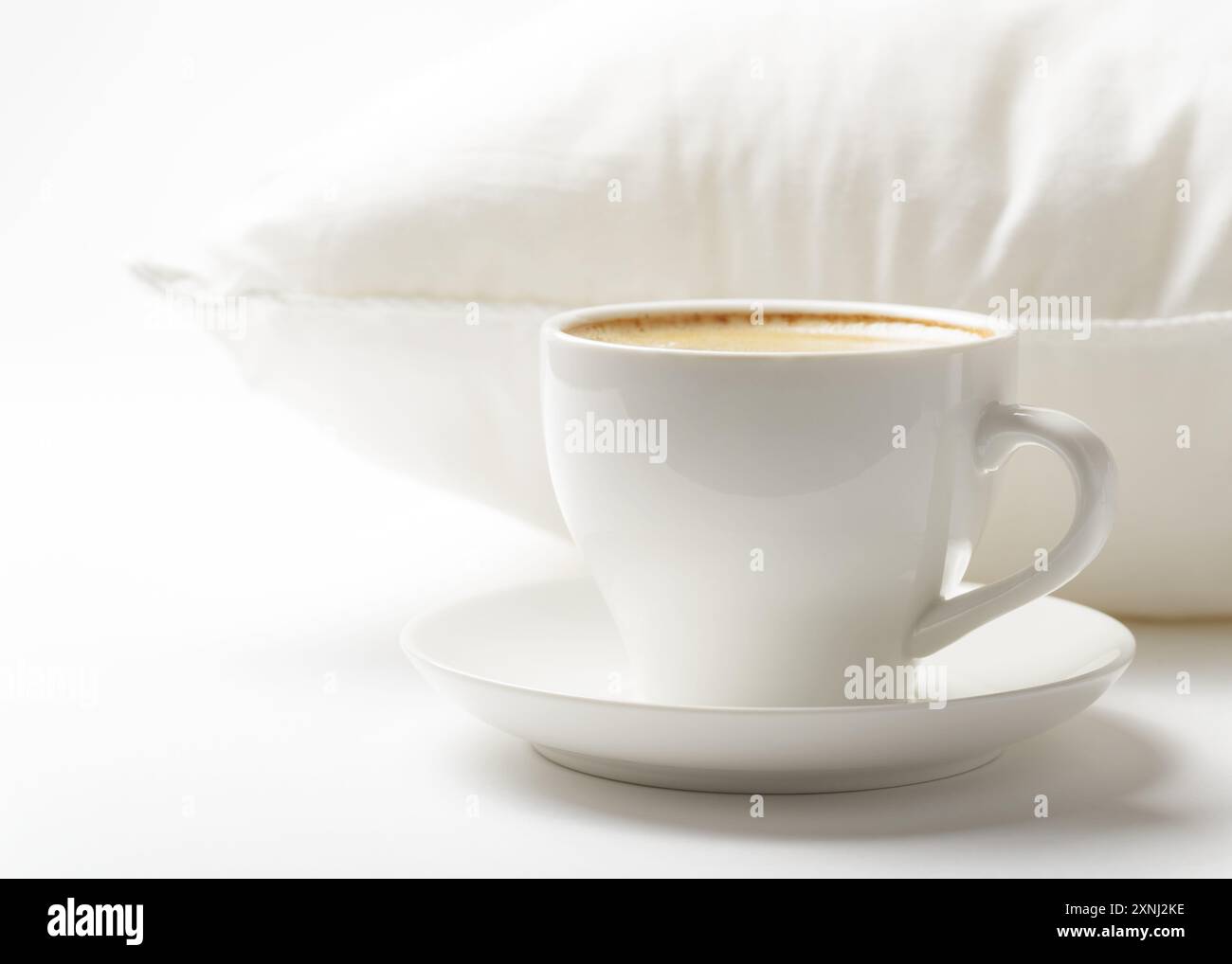 Tasse Kaffee und weißes Kissen Stockfoto
