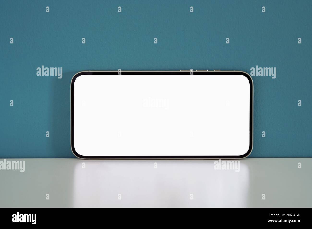 Modernes Smartphone mit leerem Bildschirm mit weißem Display vor blauem Hintergrund, perfekt für Präsentationen mobiler Apps Stockfoto