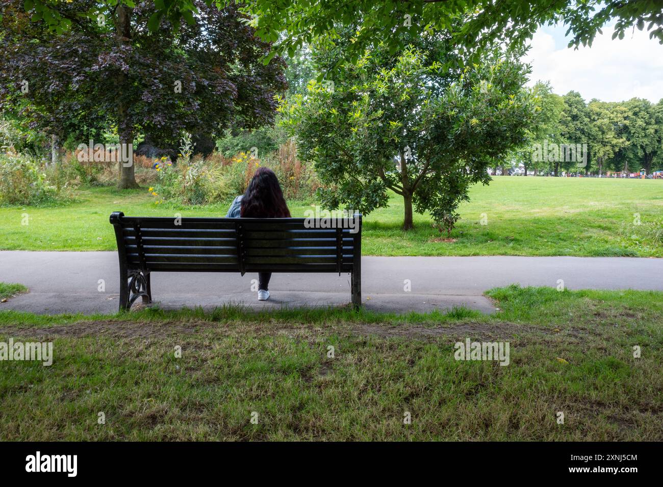 Frau saß auf einer Bank im Park Stockfoto