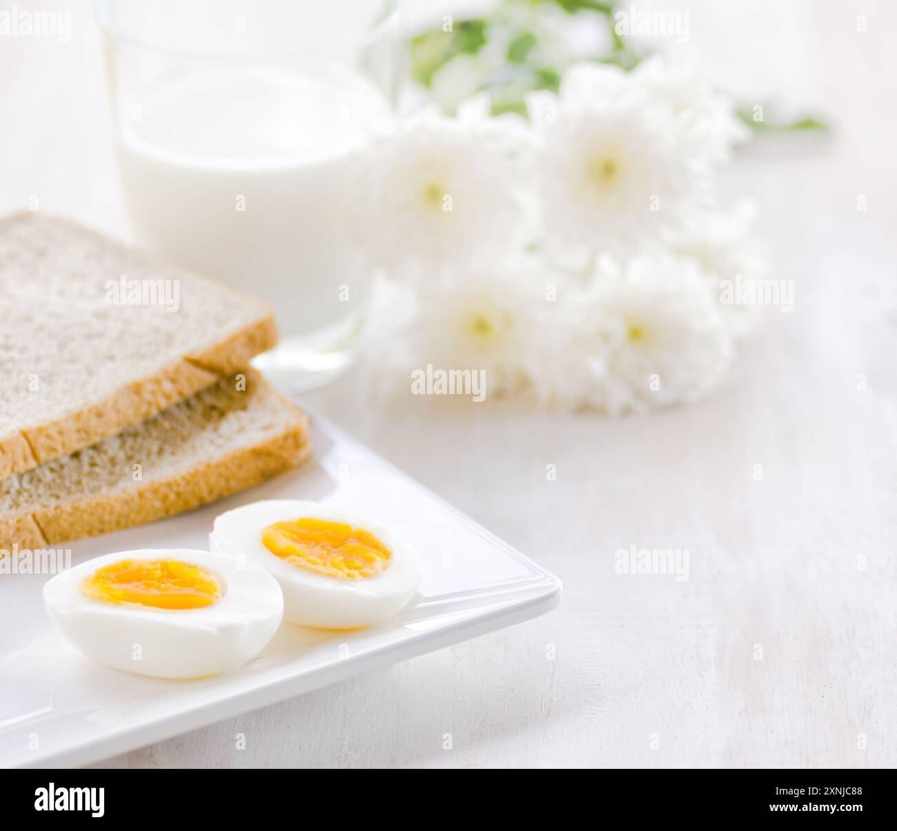 Gekochte Eier, Toast und ein Glas Milch Stockfoto