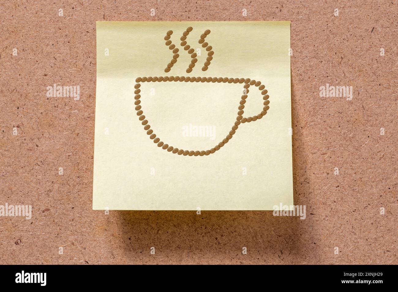 Heiße Tasse Kaffee, gezeichnet mit Kaffeebohnen auf Memorynote, die an Bord geklebt ist Stockfoto