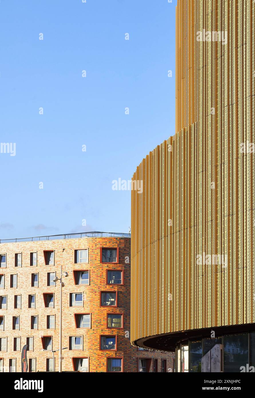 Detail der Fassadenaußenverkleidung mit Kontext in Gegenüberstellung. Swansea Arena und Copr Bay Bridge, Swansea, Vereinigtes Königreich. Architekt: acme, 2024. Stockfoto