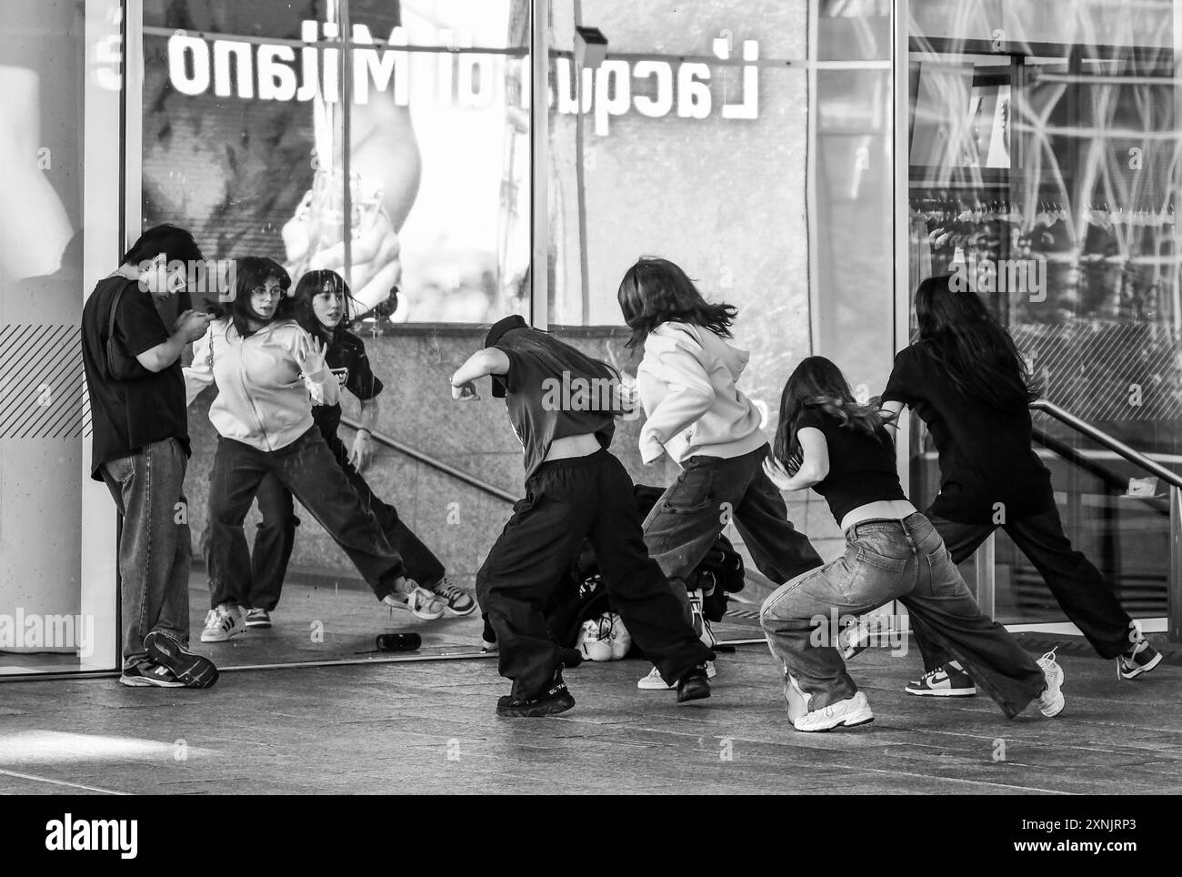 S&W. Eine kleine Gruppe von Mädchen, die einen Tanz auf TikTok auf der Piazza Gae Aulenti, Porta Garibaldi - Isola Bezirk, Mailand, Lombardei, Italien versuchen Stockfoto