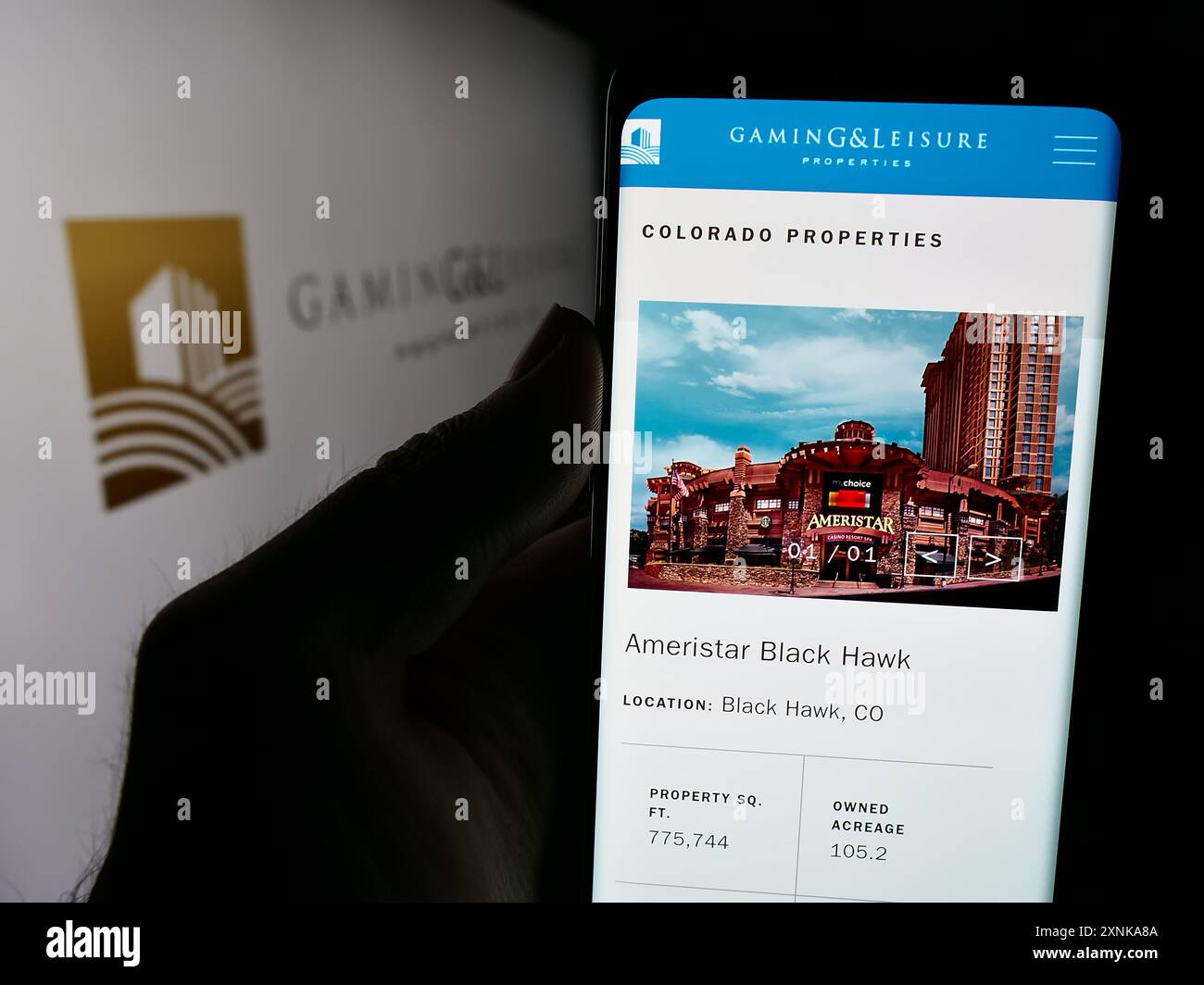 Person, die ein Mobiltelefon hält, mit Webseite des US-Immobilienunternehmens Gaming and Leisure Properties Inc. Mit Logo. Konzentrieren Sie sich auf die Mitte des Telefondisplays. Stockfoto