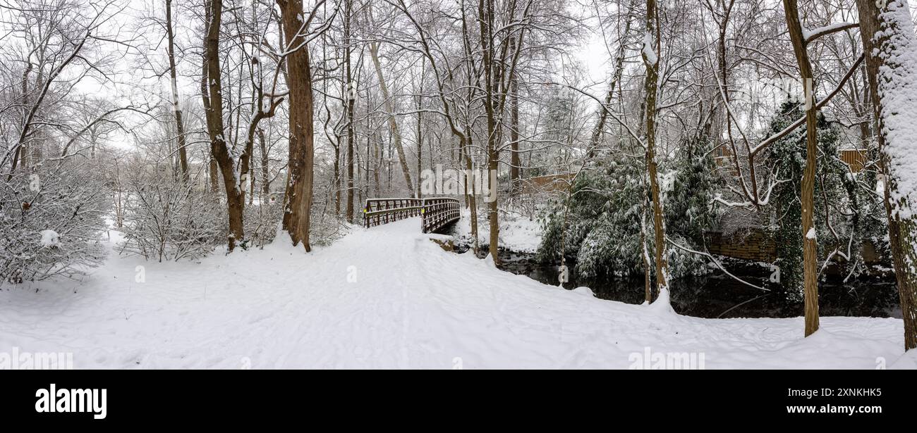Rock Spring Park Winter Snow Arlington Virginia // ARLINGTON, Virginia — Ein hochauflösender Panoramablick fängt die schneebedeckte Winterlandschaft des Rock Spring Park ein, ein 2 Hektar großes, bewaldetes Schutzgebiet, das einen historisch bedeutsamen Korridor bewahrt, auf dem einst indianische Fischerwege die Dörfer im Landesinneren mit der Fischerei am Potomac River verband. Der Park liegt an der 5012 Little Falls Road und hat seinen Namen von natürlichen Quellen, die historisch aus dem felsigen Gelände in der Gegend entstanden sind. Der Park liegt am Quellgebiet des Four Mile Run, während der Little Pimmit Run durch das Parkgelände fließt. Diese A Stockfoto