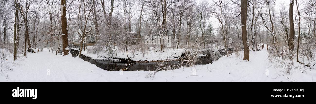 Rock Spring Park Winter Snow Arlington Virginia // ARLINGTON, Virginia — Ein hochauflösender Panoramablick fängt die schneebedeckte Winterlandschaft des Rock Spring Park ein, ein 2 Hektar großes, bewaldetes Schutzgebiet, das einen historisch bedeutsamen Korridor bewahrt, auf dem einst indianische Fischerwege die Dörfer im Landesinneren mit der Fischerei am Potomac River verband. Der Park liegt an der 5012 Little Falls Road und hat seinen Namen von natürlichen Quellen, die historisch aus dem felsigen Gelände in der Gegend entstanden sind. Der Park liegt am Quellgebiet des Four Mile Run, während der Little Pimmit Run durch das Parkgelände fließt. Diese A Stockfoto
