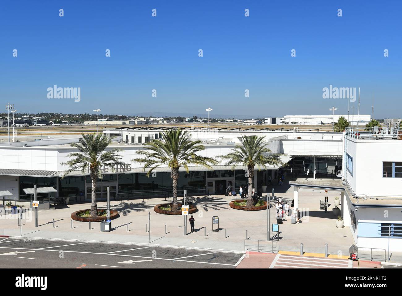 LONG BEACH, KALIFORNIEN - 28. JULI 2024: Reisende, die das Ticketgebäude am Flughafen Long Beach betreten. Stockfoto