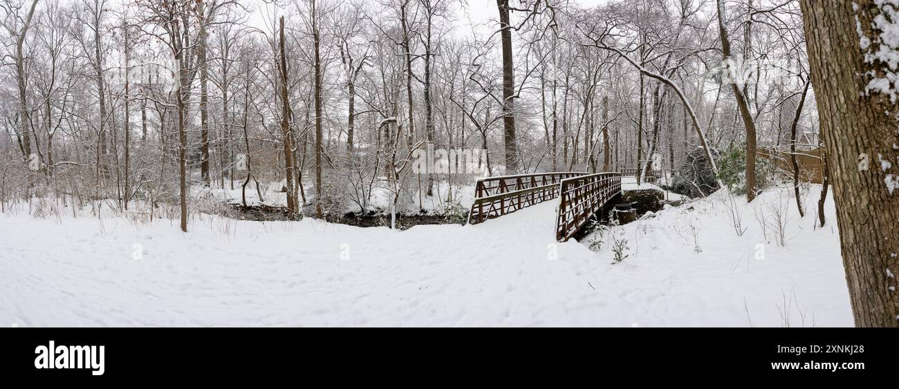 Rock Spring Park Schneeszene Arlington Virginia // ARLINGTON, Virginia — Ein hochauflösender Panoramablick fängt die schneebedeckte Winterlandschaft des Rock Spring Park ein, ein 2 Hektar großes, bewaldetes Schutzgebiet, das einen historisch bedeutsamen Korridor bewahrt, auf dem einst indianische Fischerwege die Dörfer im Landesinneren mit der Fischerei am Potomac River verband. Der Park liegt an der 5012 Little Falls Road und hat seinen Namen von natürlichen Quellen, die historisch aus dem felsigen Gelände in der Gegend entstanden sind. Der Park liegt am Quellgebiet des Four Mile Run, während der Little Pimmit Run durch das Parkgelände fließt. Diese ab Stockfoto