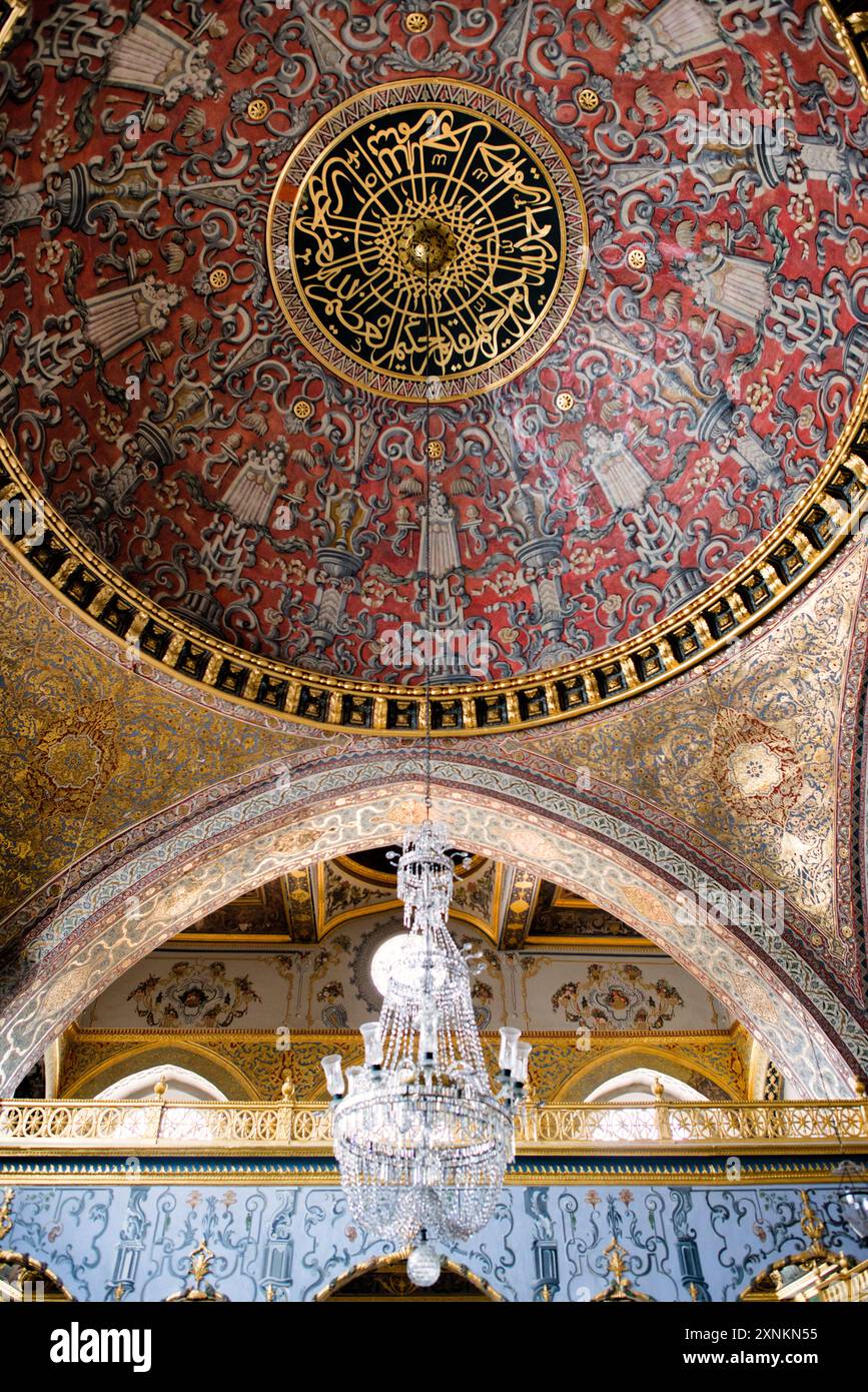 ISTANBUL, Türkei / Türkiye — die Kuppeldecke im opulenten Thronsaal des Kaiserreichs im Harem des Topkapi-Palastes, Istanbul. Diese aufwendig verzierte Kammer, die mit komplizierten Iznik-Fliesen, vergoldeten Ornamenten und reichen Möbeln geschmückt war, diente als privater Audienzsaal für den osmanischen Sultan innerhalb der abgeschiedenen Grenzen des kaiserlichen Harems. Der Raum spiegelt die künstlerische Meisterschaft und den Luxus der osmanischen kaiserlichen Architektur wider und bietet einen Einblick in die Welt des osmanischen Hofes. Stockfoto