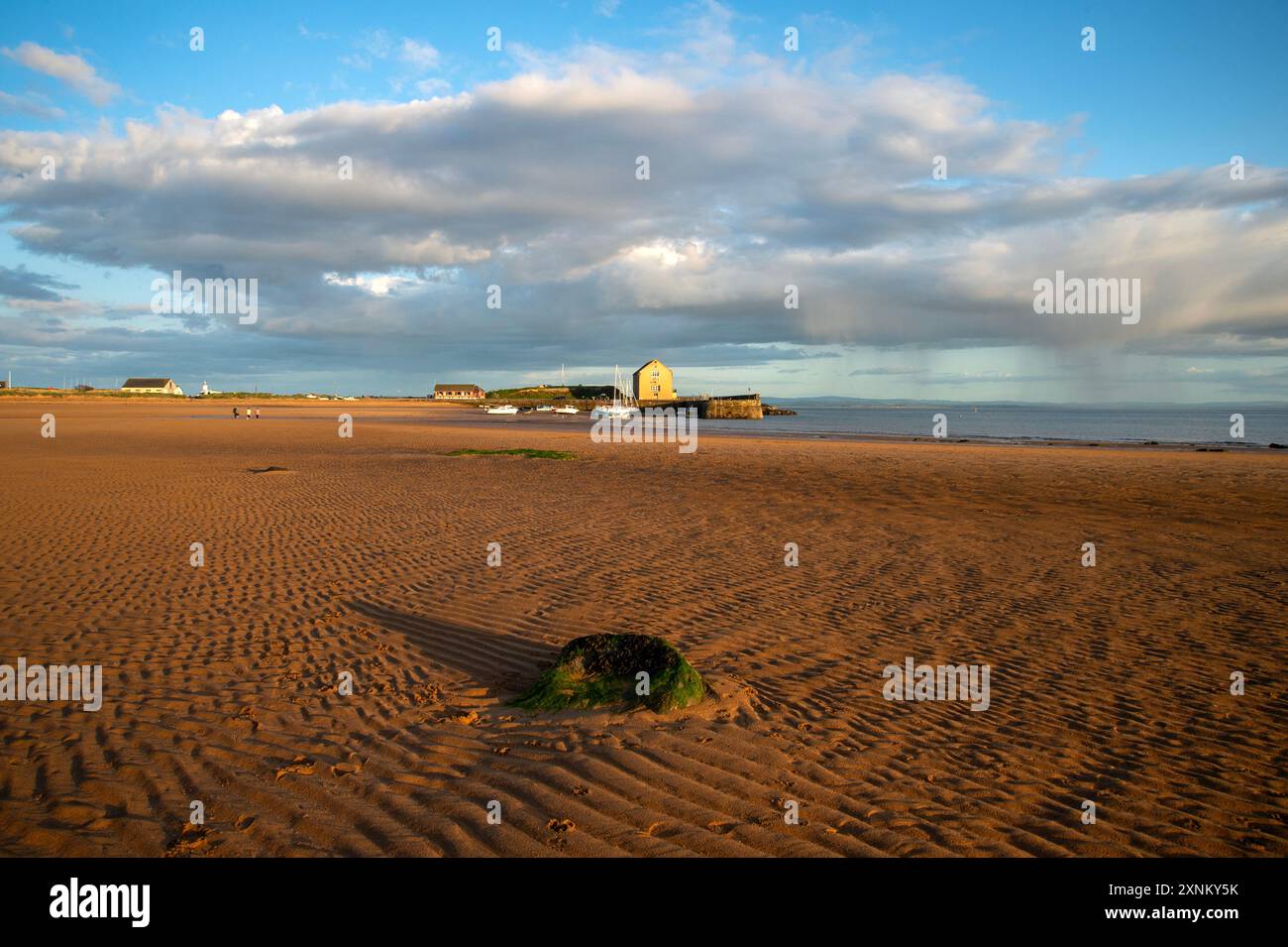 Elie Hafen und Kornspeicher leuchten durch das goldene Sonnenuntergangslicht über den Gezeiten des Sandes Elie Fife Scotland Stockfoto