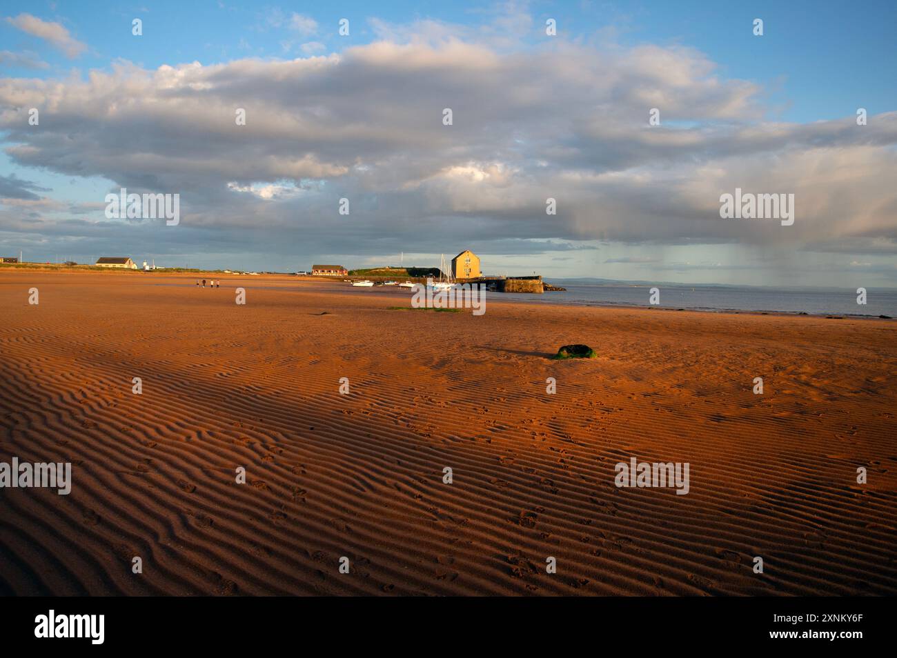 Elie Hafen und Kornspeicher leuchten durch das goldene Sonnenuntergangslicht über den Gezeiten des Sandes Elie Fife Scotland Stockfoto
