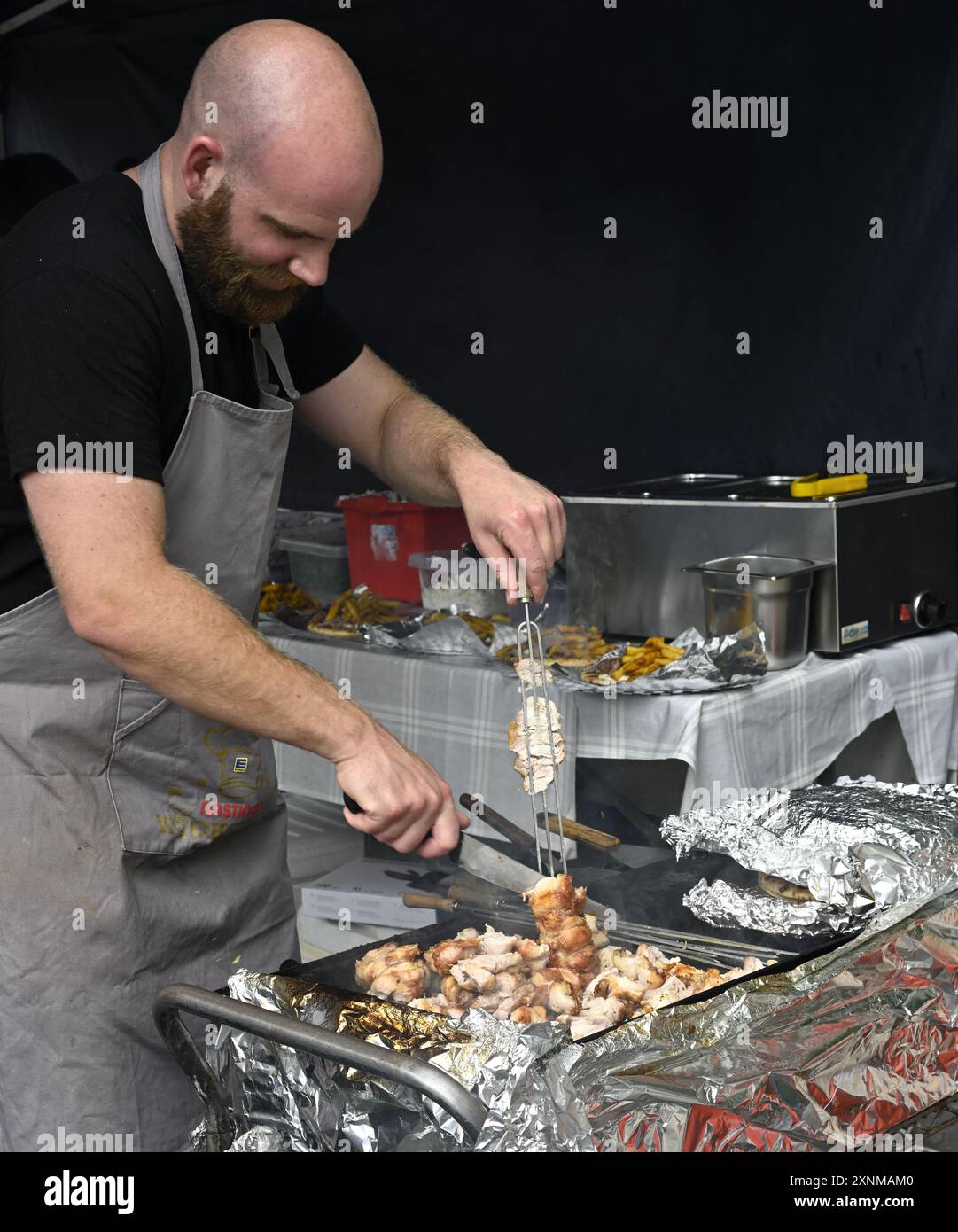 Koch bereitet Speisen auf dem Grill für Döner zum Mitnehmen beim Festival zu Stockfoto