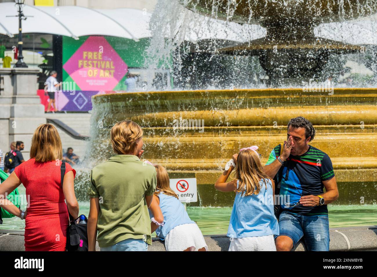 London, Großbritannien. August 2024. Die Mini-Hitzewelle hängt an und veranlasst die Menschen, das Wasser in den Springbrunnen des Trafalgar Square zur Abkühlung zu nutzen. Guy Bell/Alamy Live News Stockfoto