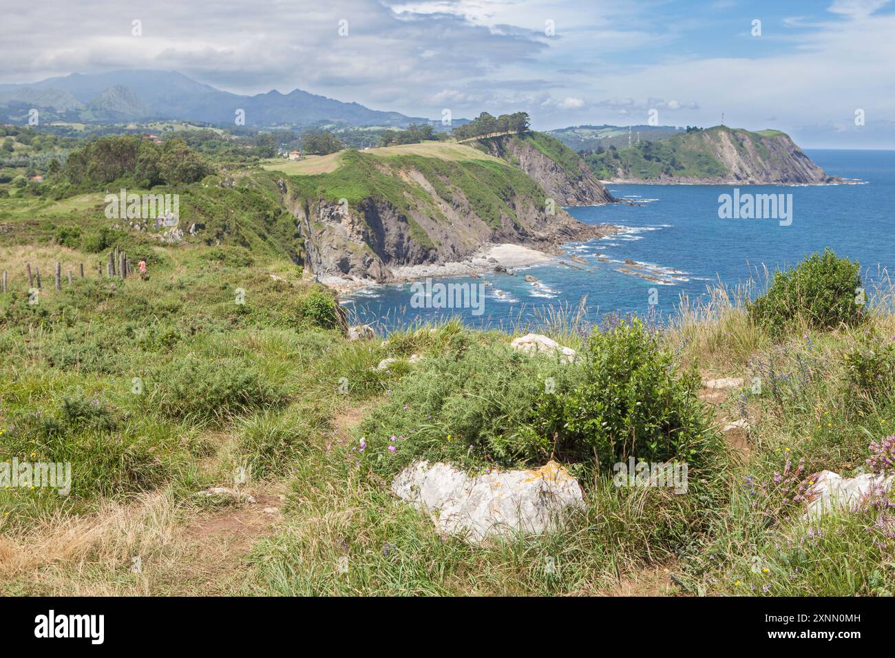 Frau in Rot, die neben den Klippen der Hölle läuft, Ribadesella Ost-Asturien, Spanien Stockfoto