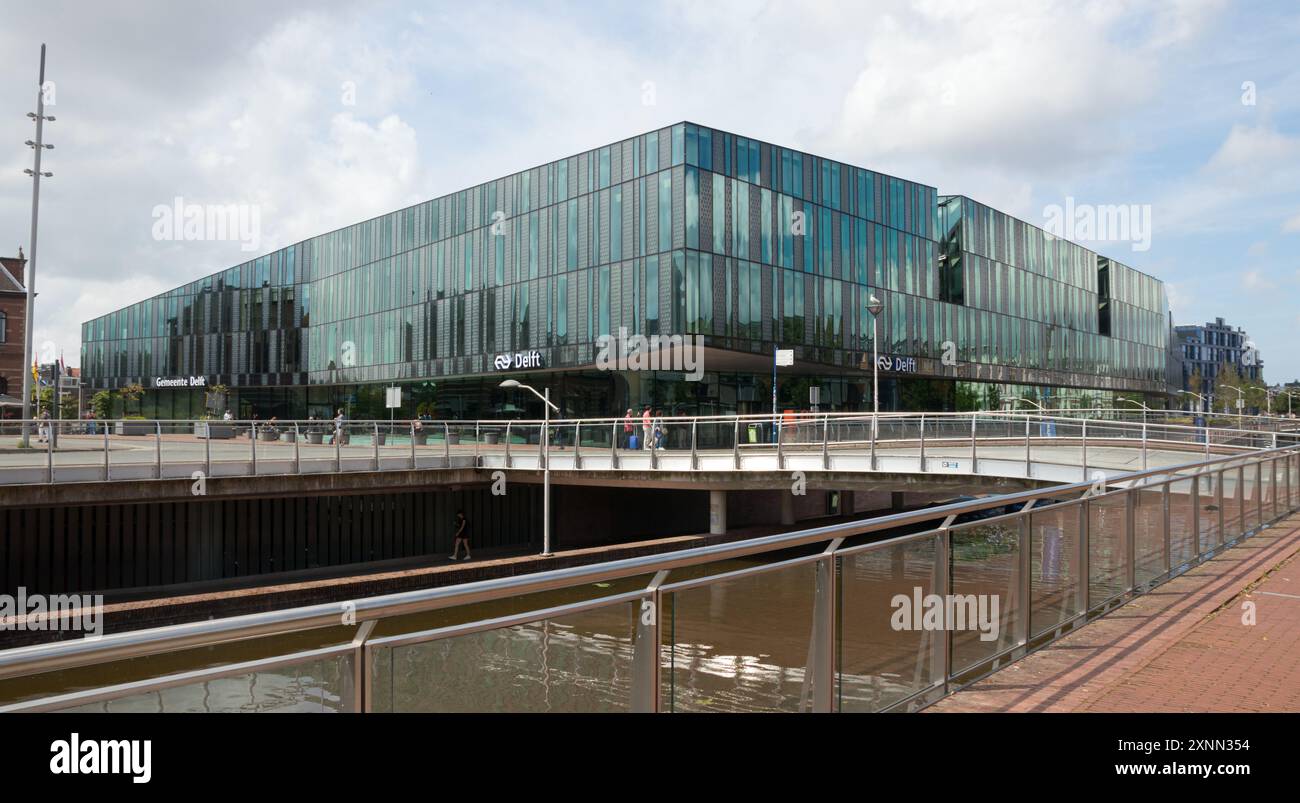 DELFT, SÜDHOLLAND, NIEDERLANDE - 26. JULI 2024: Blick auf den Bahnhofsplatz mit dem Bahnhof Delft und dem Rathaus. Stockfoto