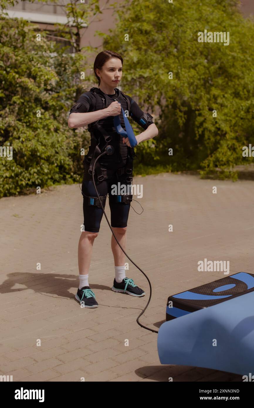 Urban Fitness, Frau, die EMS-Training mit Widerstandsbändern auf der Straße macht Stockfoto