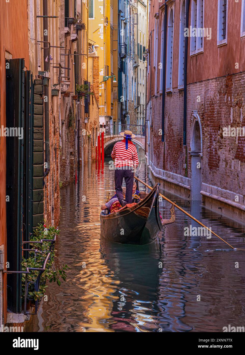Schmaler Kanal mit Gondel und Brücke in Venedig, Italien. Stockfoto