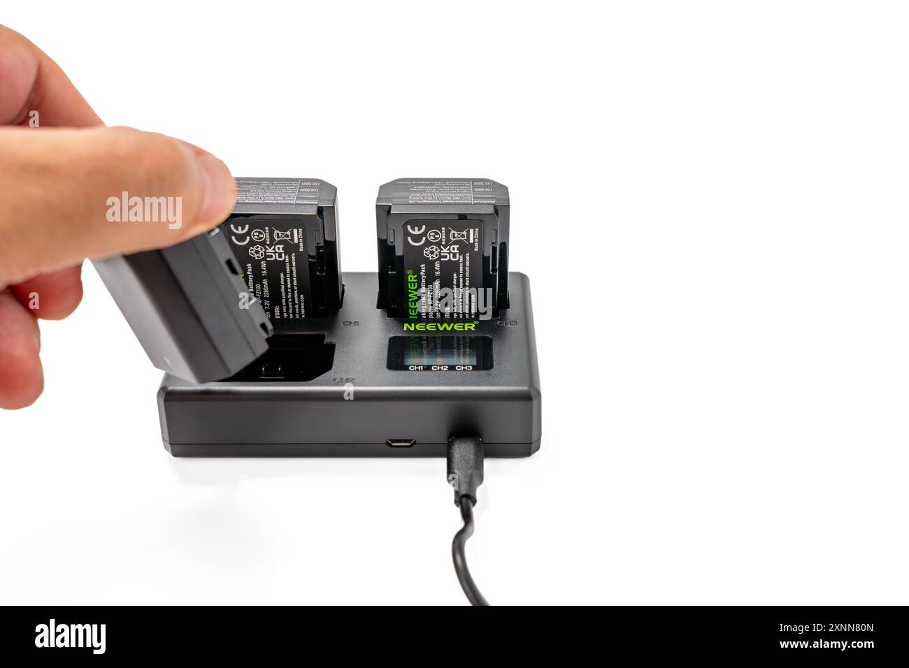 Deutschland Berlin 1. August 2024. NEEWER NP-FZ100 Ersatzakku und Ladegerät isoliert auf weißem Hintergrund. USB-Ladegerät mit drei Anschlüssen. Stockfoto