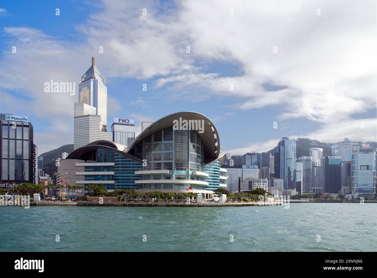 Das Hong Kong Convention and Exhibition Centre an einem sonnigen Tag mit der Skyline im Hintergrund. Hongkong - 29. Mai 2024 Stockfoto