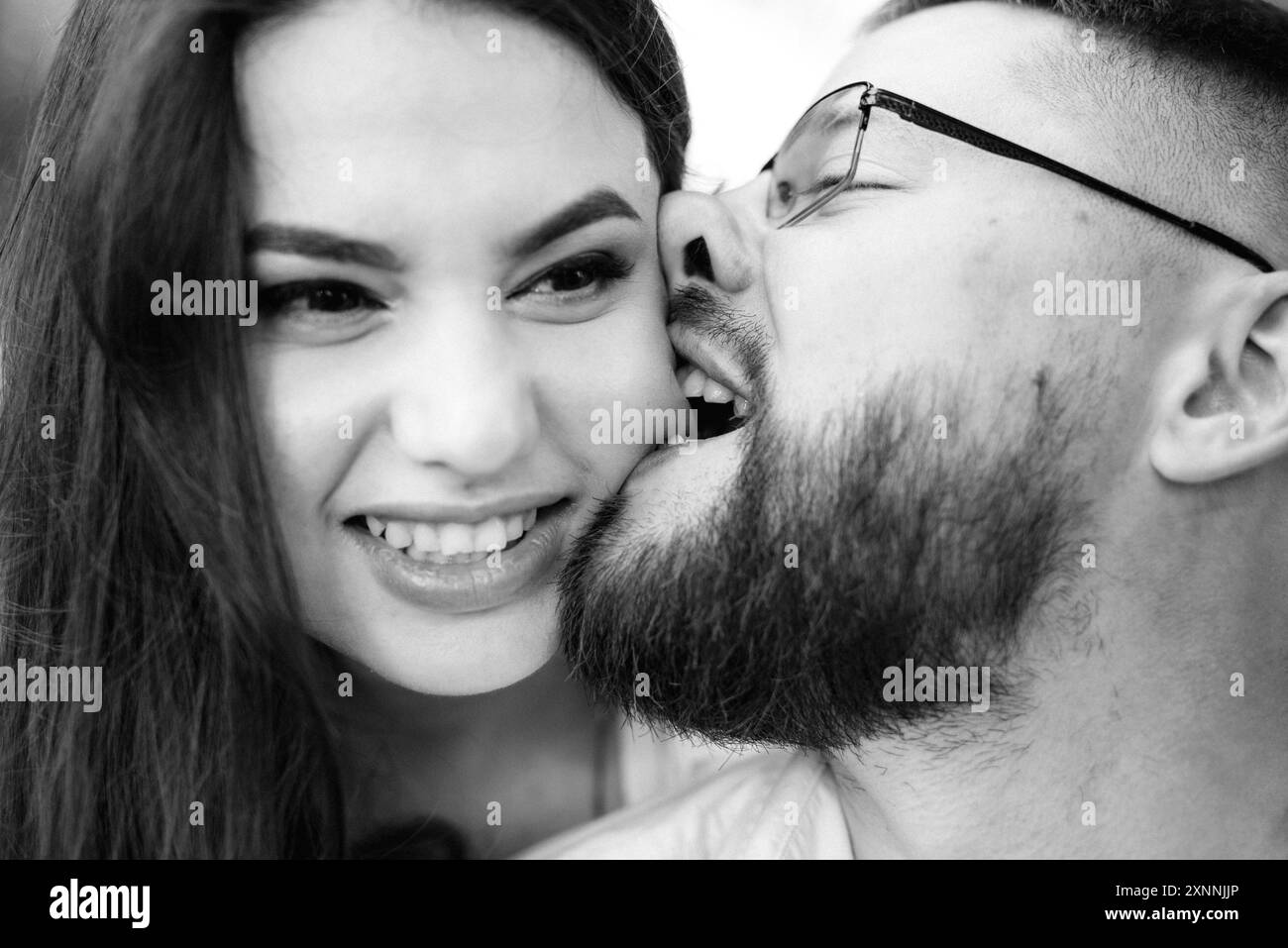 Junges Paar in der Liebe ein Kerl mit einem Bart und Ein Mädchen mit dunklen Haaren in hellen Kleidern in der Grüner Wald Stockfoto