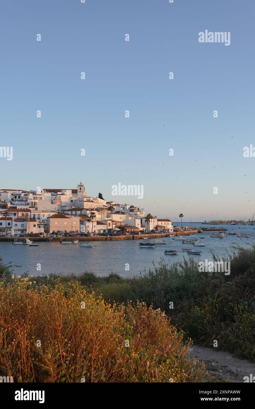 Golden Hour Überblick über Ferragudo Piscatory Village mit Fluss und Booten Stockfoto