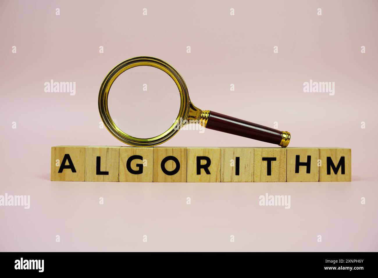 Lupe und Papierkarte mit TEXTALGORITHMUS auf rosa Hintergrund Stockfoto