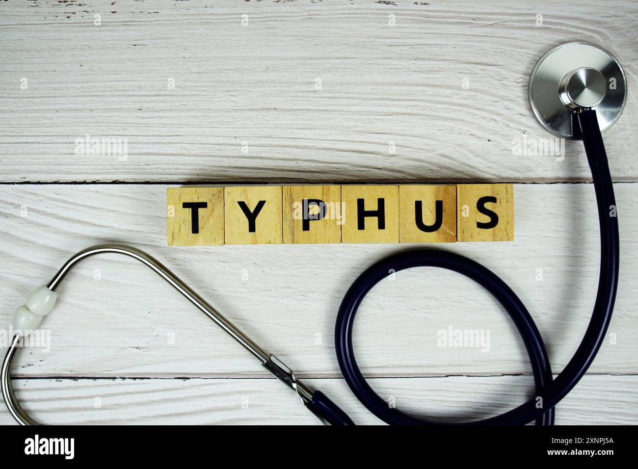 Typhus mit Holzblöcken Buchstaben und Stethoskop auf hölzernem Hintergrund, gesund und Wellness Konzept Stockfoto
