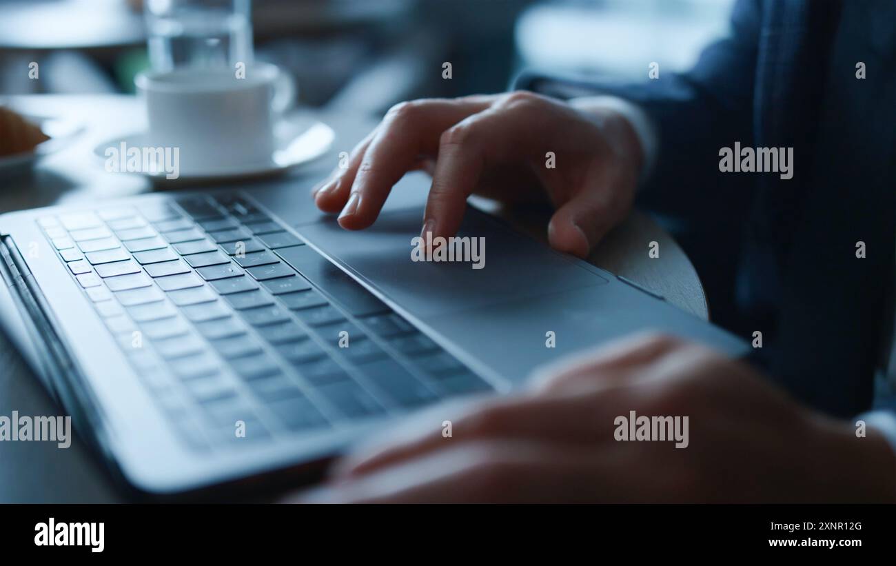 Die Hände des Mannes tippen auf der Laptop-Tastatur. Geschäftsmann, der im Loft-Büro mit Laptop surft. Geschäftsmann, der an einem Laptop arbeitet, aus der Ferne studiert Stockfoto