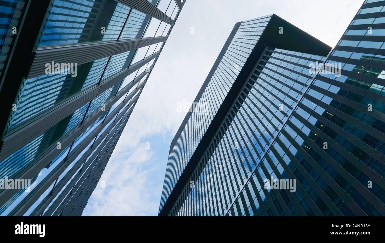 Wirtschafts-, Bank-, Wirtschafts- und Finanzkonzept. Ein Fragment eines modernen Bürogebäudes in der Hauptstadt. Glasgebäude mit wolkenblauem Himmel Stockfoto