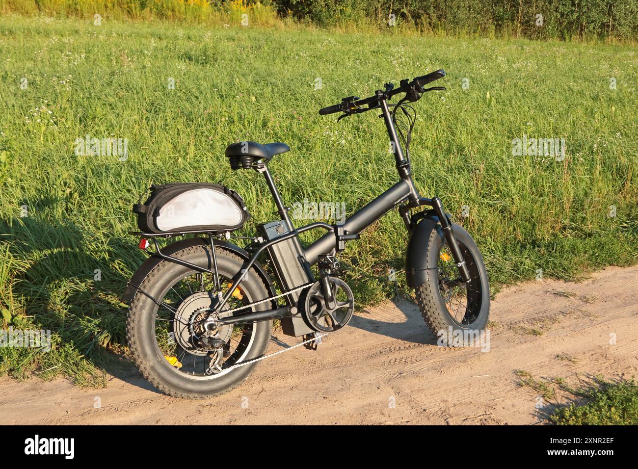 Elektrisches Klappfahrrad für Fahrten in der Natur auf dem Land. Sport und Gesundheit. Sommer-Hobby. Stockfoto
