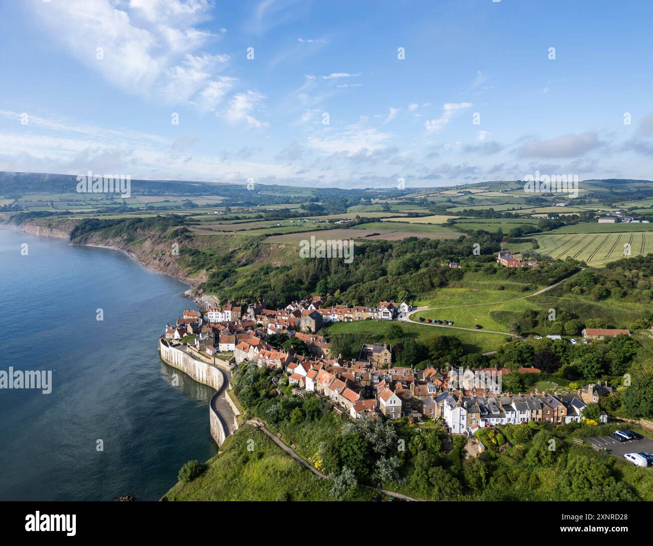 Aus der Vogelperspektive auf Robin Hood's Bay mit Klippen und Farmland, North Yorkshire, England. Stockfoto