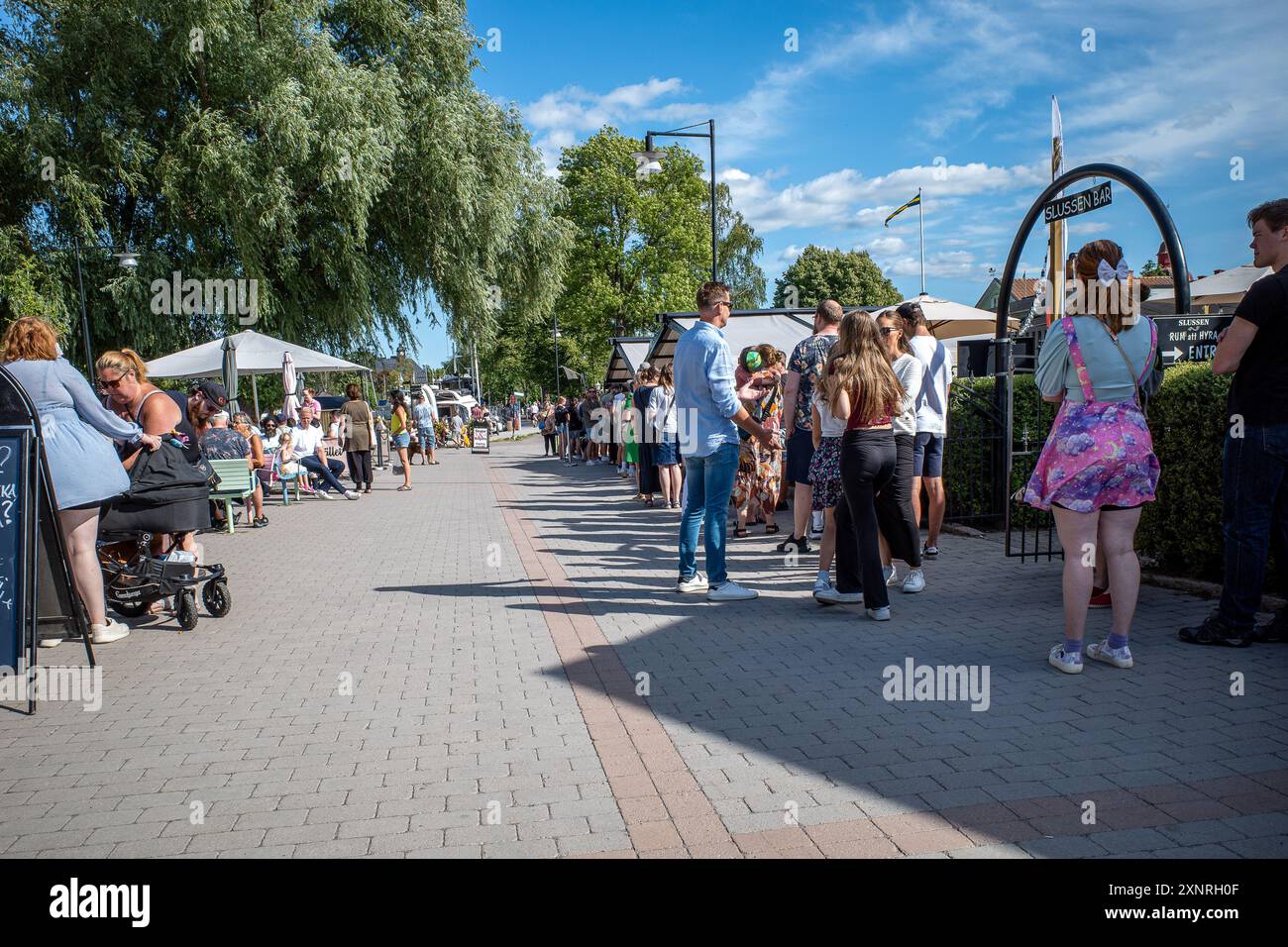 Touristenanstehen für isce-Sahne im beliebten Eiscafé Smultronstället. Söderköping ist eine historische Stadt und ein beliebtes Reiseziel in Schweden Stockfoto