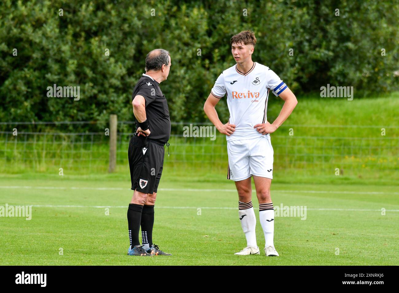 Swansea, Wales. 27. Juli 2024. Match-Schiedsrichter Garwyn Davies spricht mit Kiel Higginson aus Swansea City während des U18-Freundschaftsspiels zwischen Swansea City und Leyton Orient am 27. Juli 2024 auf dem Fairwood Training Ground in Swansea, Wales, Großbritannien. Quelle: Duncan Thomas/Majestic Media/Alamy Live News. Stockfoto