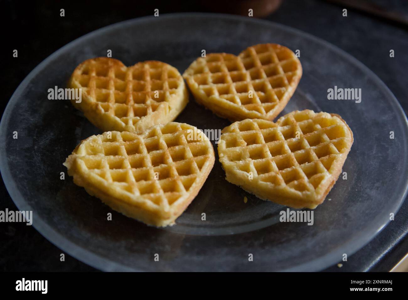 Vier Liebesherzwaffeln serviert auf einem Teller Stockfoto