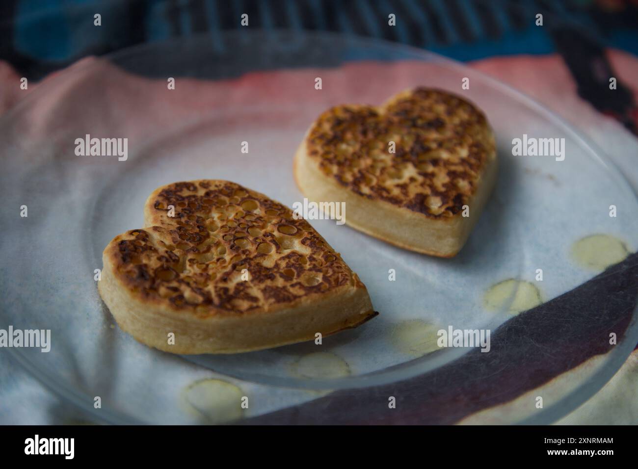Zwei Liebesherz-Crumpets auf einem Teller serviert Stockfoto