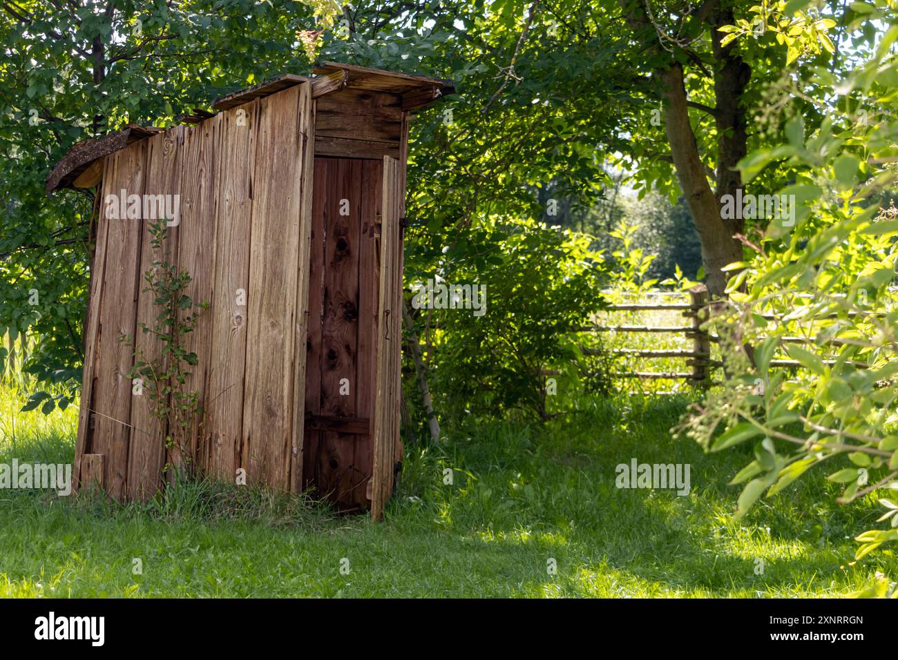 Eine alte hölzerne Toilettenkabine im Landgarten Stockfoto