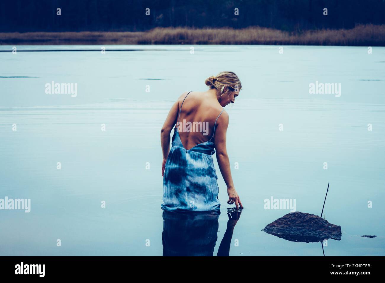 Leben im Freien - Frau im Kleid badet in einem kalten nordischen See Stockfoto