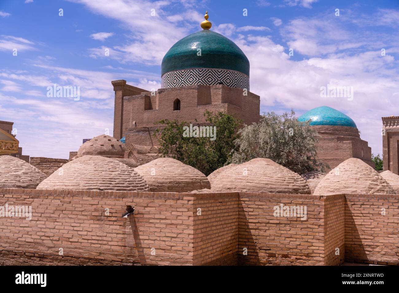 Ein großes Gebäude mit einer grünen Kuppel befindet sich vor einer Backsteinmauer Stockfoto